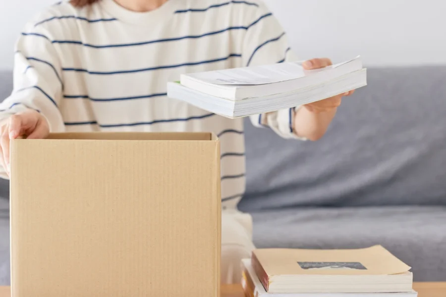 Person trennt Müll und recycelt Materialien beim nachhaltig Entrümpeln.